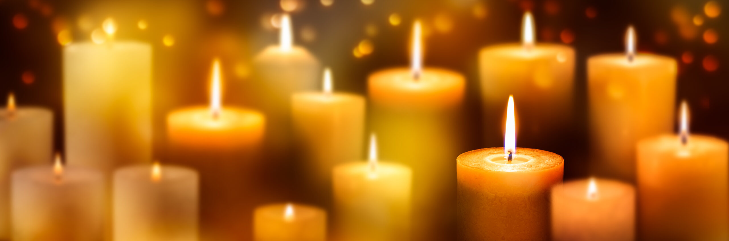 viele unscharfe brennende kerzen vor goldenem hintergrund, weihnachtsdekoration, festliches konzept für feiertage
